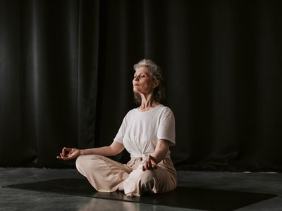 A person hand resting in a mudra position during meditation.